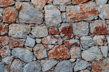 Modern wall of large unprocessed pieces of rock, stones. Background stone wall.