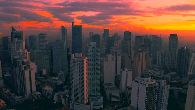 Beautiful sunrise above the high rise buildings in Manila city, Philippines. Aerial 4K