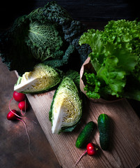 Savoy cabbage and other garden vegetables on an old board