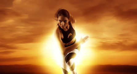 Sporty woman running. Sunset background