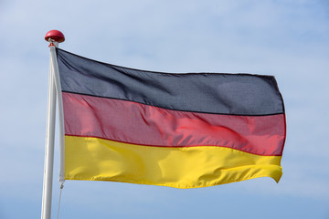 German flag waving against blue sky