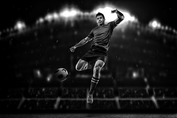 Fototapeta na wymiar Soccer player in action on a dark background