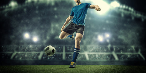 Obraz na płótnie Canvas Soccer player in action on night stadium background