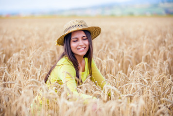 Naklejka na ściany i meble portrait of the rural girl in a straw hat