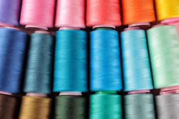 Accessories for sewing and needlework. Many multi-colored spools of thread. Bobbins with colored thread