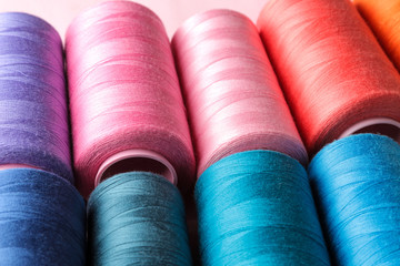 Accessories for sewing and needlework. Many multi-colored spools of thread. Bobbins with colored thread