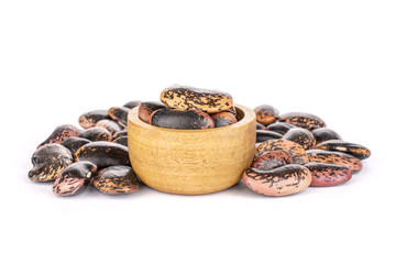 Lot of whole stained purple bean in tiny wooden bowl isolated on white background
