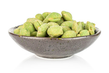 Lot of whole spicy green wasabi peanut in dark ceramic bowl isolated on white background