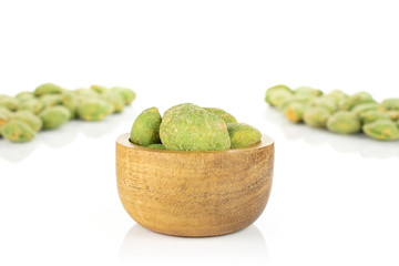 Lot of whole spicy green wasabi peanut two groups are in the back and the rest is in tiny wooden bowl isolated on white background