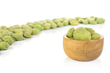 Lot of whole spicy green wasabi peanut in tiny wooden bowl isolated on white background
