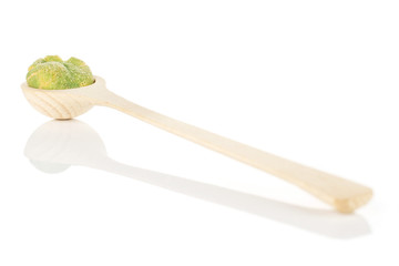 Group of three whole spicy green wasabi peanut in a wooden spoon isolated on white background