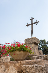 Metal cross on the ruins of the temple of Byzantine times in the territory catholic Christian...
