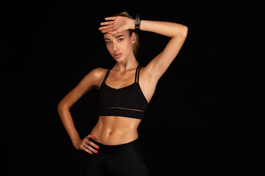 Girl Wiping Sweat From Face After Workout, Black Background