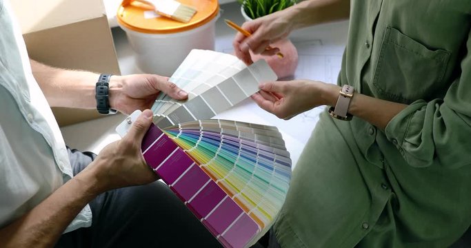 people discussing and choosing paint color from swatch for new home interior design