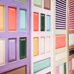Abstract architecture background in diverse muted pastel colors. Colorful African door closeup in soft watercolors of purple, pale pink, blue green, orange, black, white and brown. Selective focus.