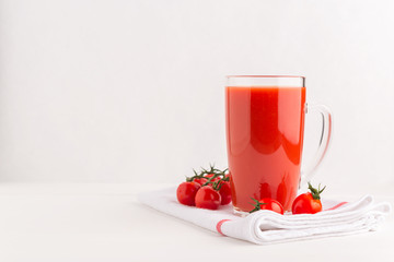Fresh Tomato juice in a Cup on  napkin with cherry tomatoes