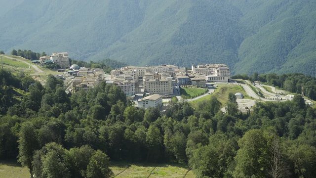 Aerial view of ski resort and alpine village in Mountains in summer sunny day. Tourism concept