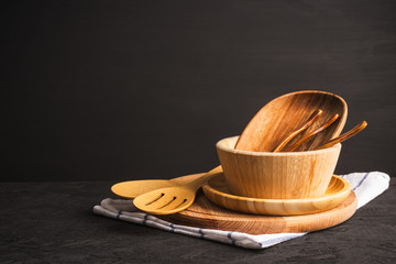 Wooden kitchen utensils and accessories for cooking on dark background