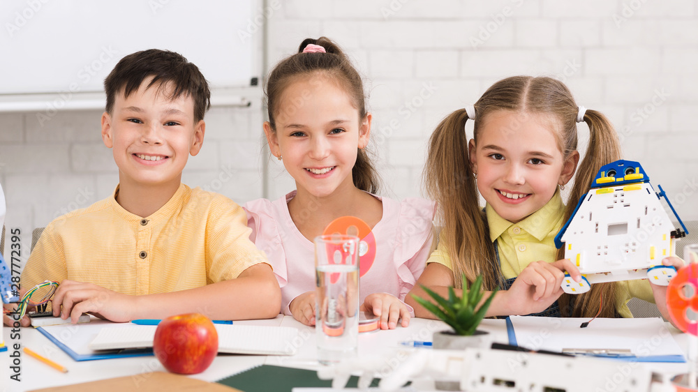 Poster stem education. children building robots in classroom