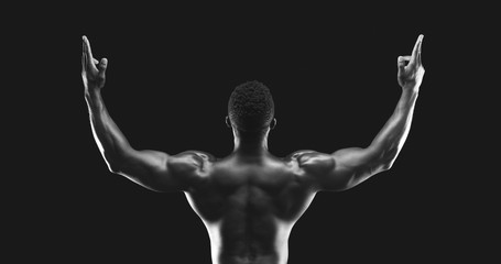 Rear view of black athlete raising hands up
