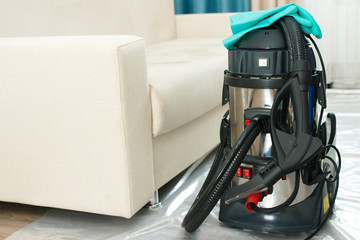 A steam cleaner for cleaning furniture is on the floor