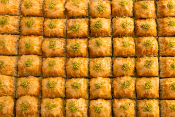 Top view texture of traditional turkish dessert baklava in the shop window showcase. Popular souvenirs and snacks from Turkey. .