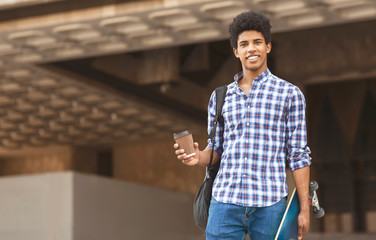 Attractive young guy walking in the city drinking takeaway coffee