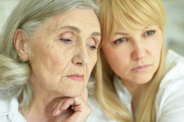 Portrait of sad senior woman with daughter