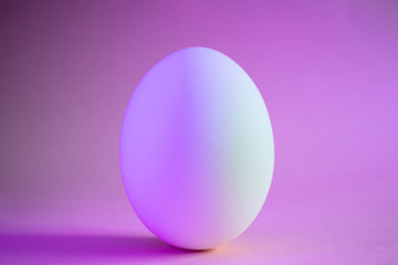 Close-up egg in neon trend purple color. Protein, a stylish simple meal. Minimalism, place for text, design.