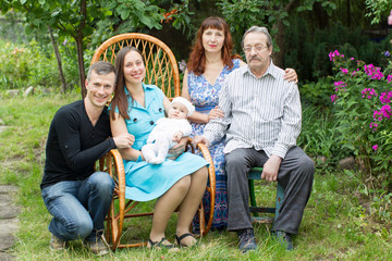 Family portrait in the garden. Grandma grandpa mom dad and baby