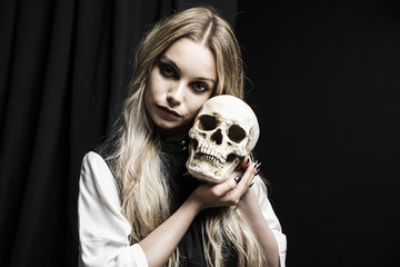 Blonde woman holding human cranium