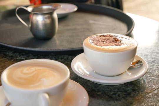 Cup of cappucino and Flat White coffee on table in a cafe