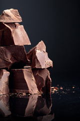 Pieces of dark chocolate on a dark background.