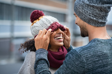 Man and woman playing with winter cap
