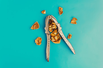 Nutcracker for nuts and walnut on blue background
