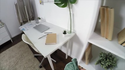 POV shot of man wiping bookshelves and desk with microfiber cloth while cleaning the dust at home