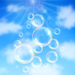 Realistic transparent floating soap bubbles on blue sky background. Design element for advertising booklet, flyer or poster