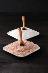 Sea salt and himalayan in bowl. Crystals of salt on dark background