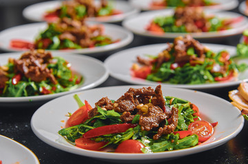 A lot of plates with salad on the table.