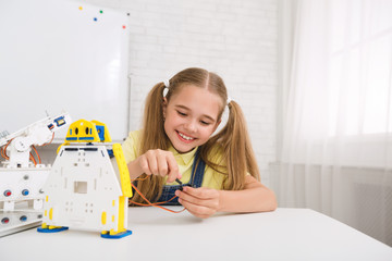 Stem education. Schoolgirl working with wires in classroom