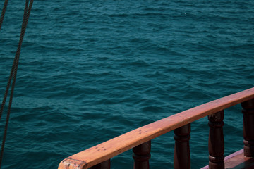 Ship's old wooden side, with various ship attributes on the background of the ocean