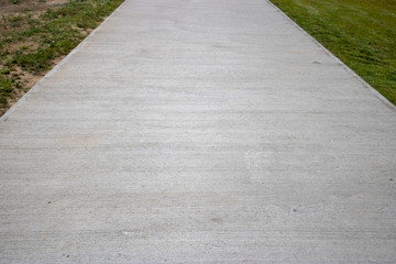 A concrete path with grass at the side