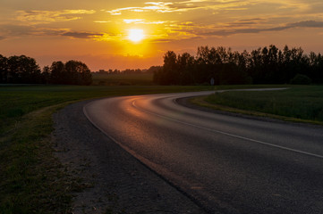 Vivid orange tropical sunset with curving road