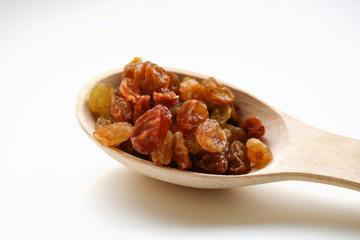 White grape raisins in a wooden spoon. sabza. on a white background..