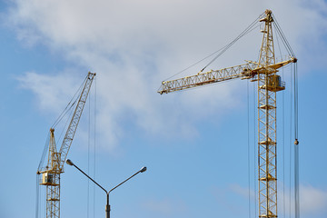 Crane at a construction site against the blue sky.