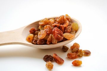 White grape raisins in a wooden spoon. sabza. on a white background..
