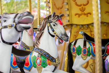 Fototapeta na wymiar Fragment of a French carousel with horses. Children's attraction.