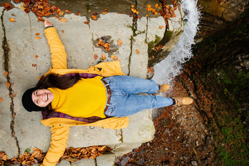 happy woman at the cliff near waterfall