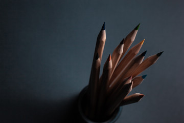 Sharpened pencils of different colors made of light wood isolated on black background.