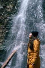 Obraz premium woman near waterfall in forest autumn season